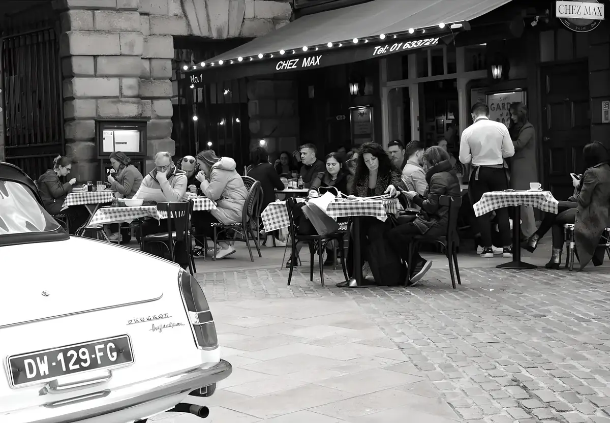 Black-and-white view of the Chez Max terrace on Palace Street, with the Peugeot 404 parked out front