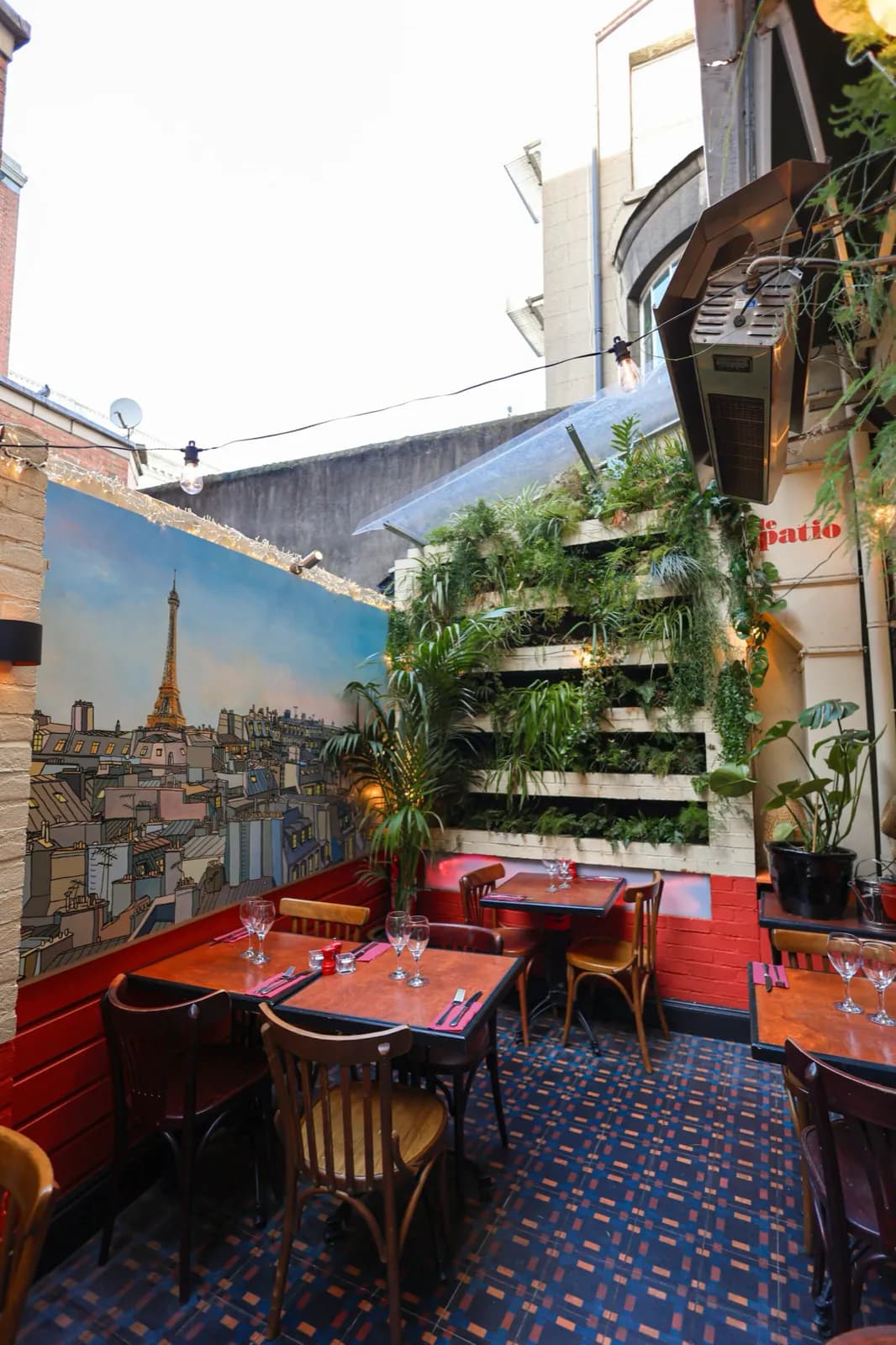 The heated patio at Chez Max, with a mural of Paris rooftops and the Eiffel Tower