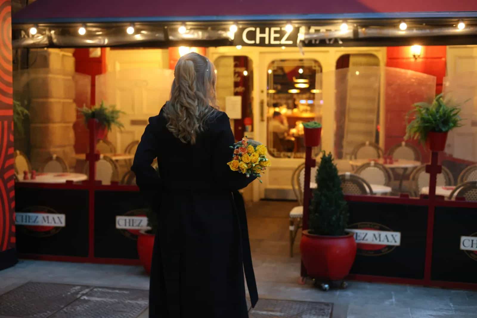 The warmly lit Chez Max façade on Palace Street at dusk