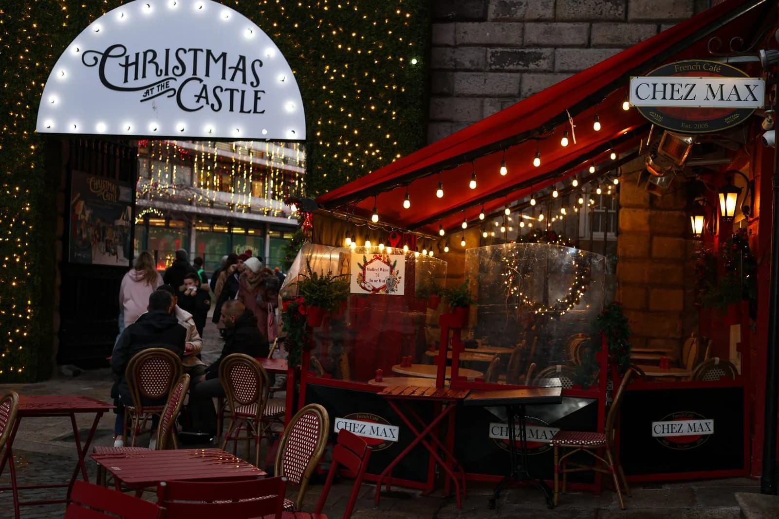 The Chez Max terrace lit up for Christmas at the Castle, festoon lights and garlands over the tables