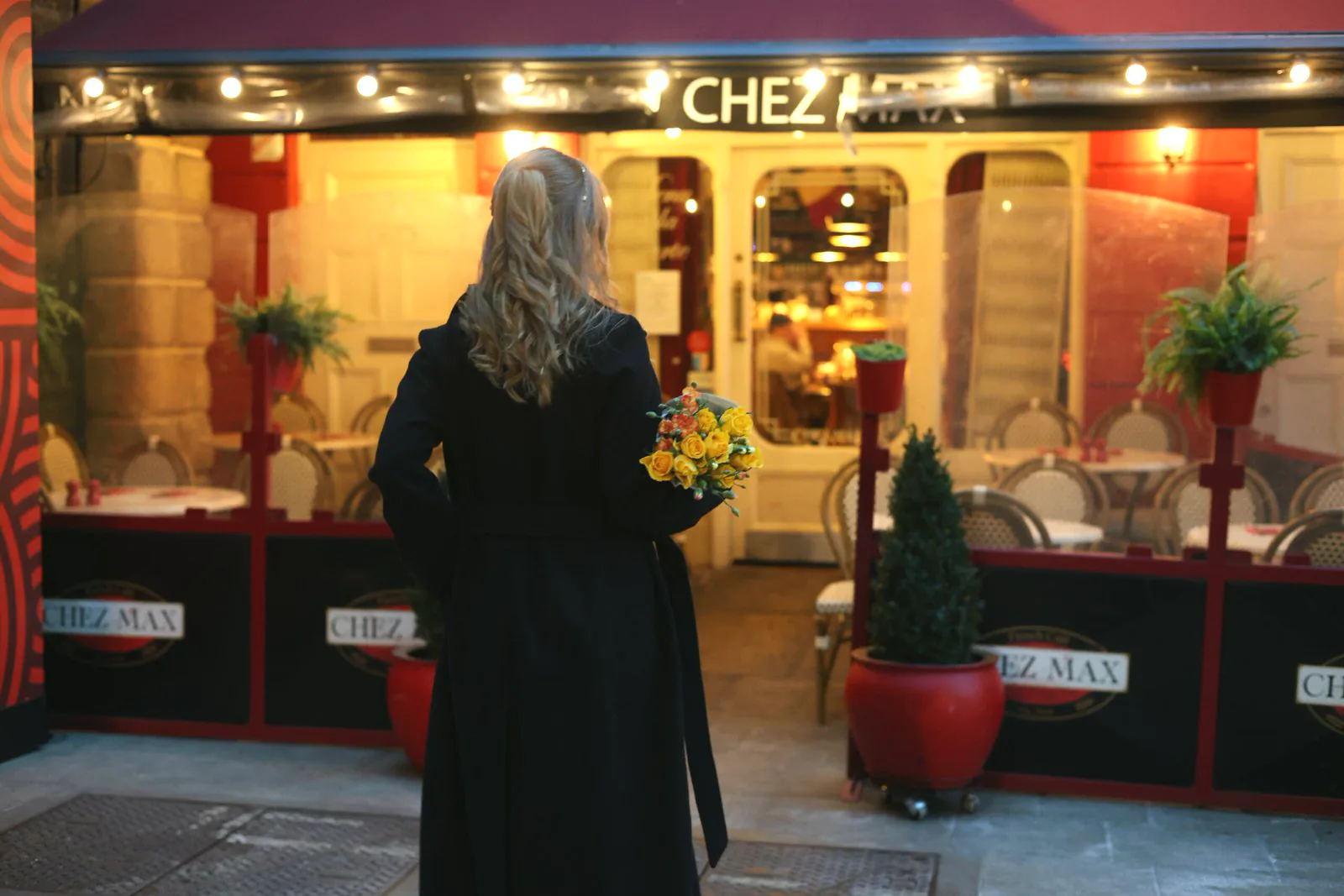 The warmly lit Chez Max façade on Palace Street at dusk