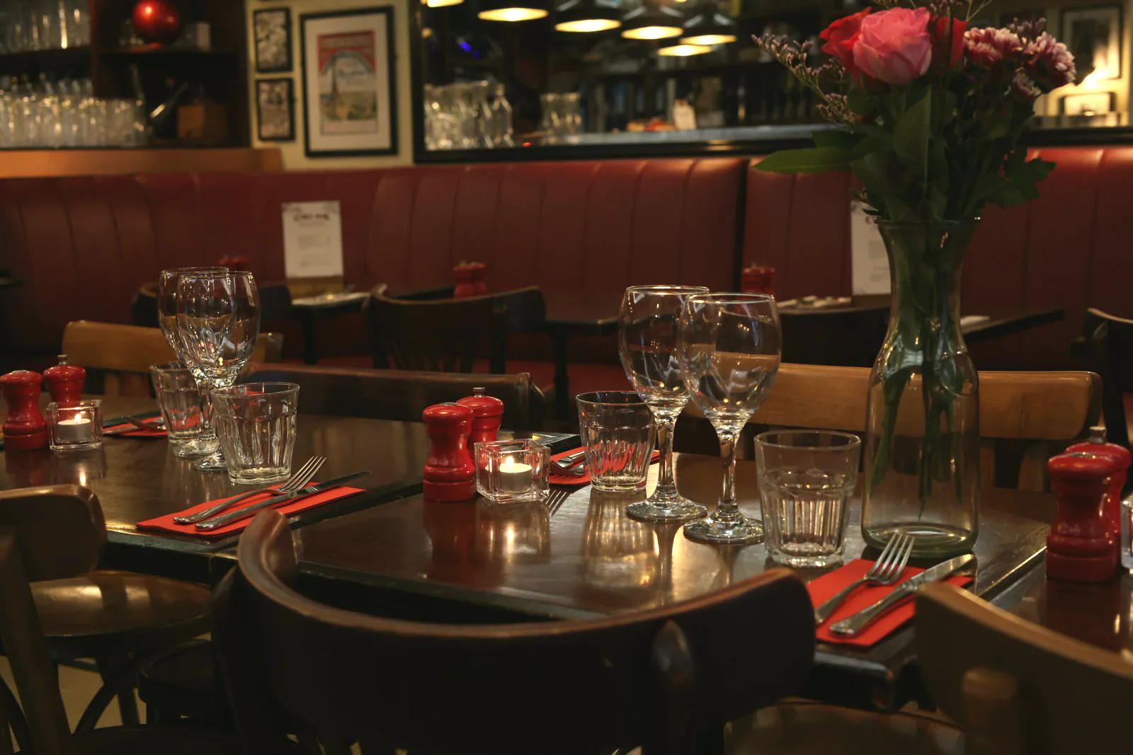 Candlelit tables at Chez Max, wine glasses and fresh roses set for dinner